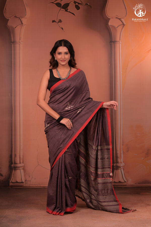Woman wearing a traditional handwoven kutchhi weave saree with a decorative background in fine cotton yarns with silk threads in extra weft design.