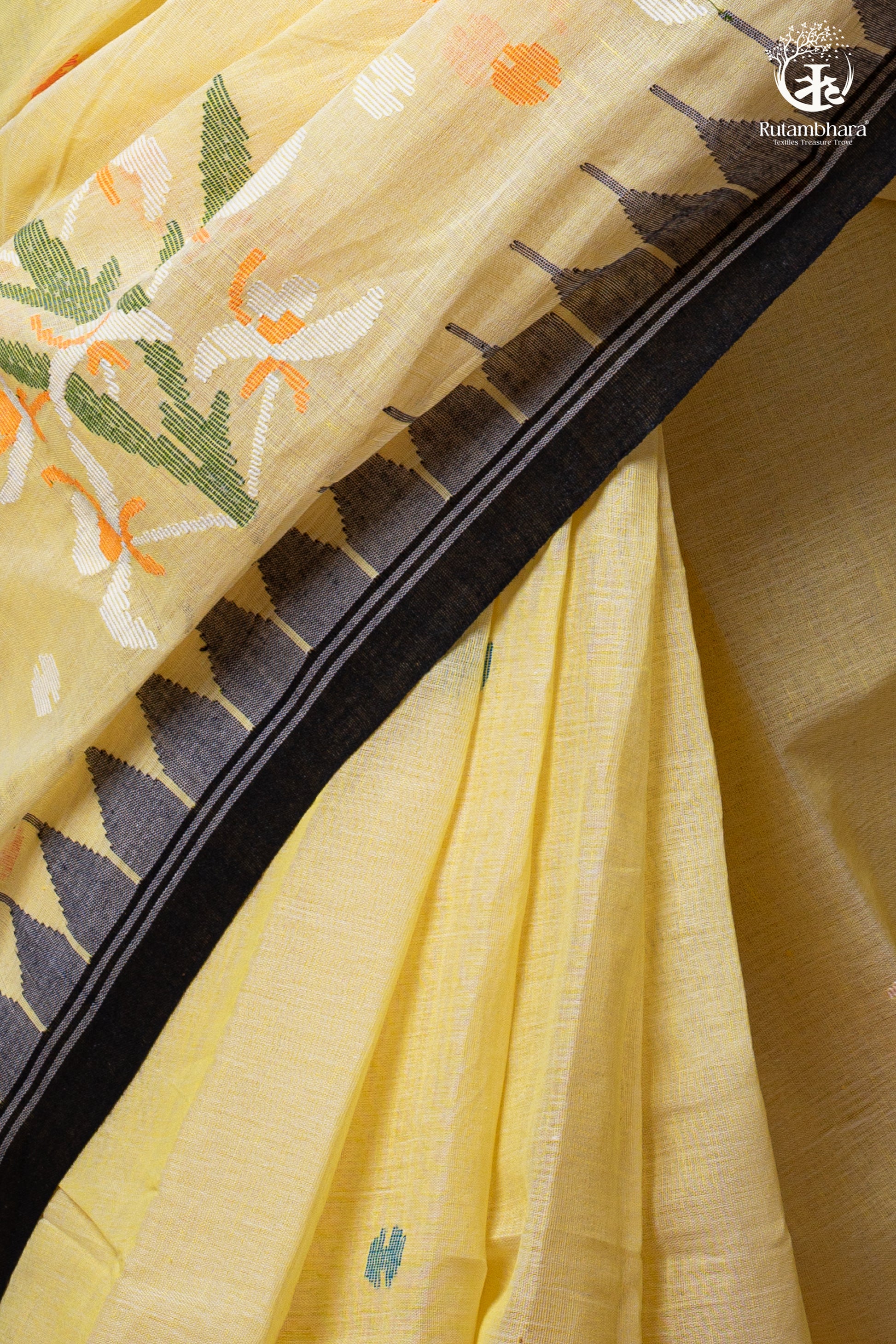 Close-up of a yellow fabric with floral patterns and black border to display the texture of the saree