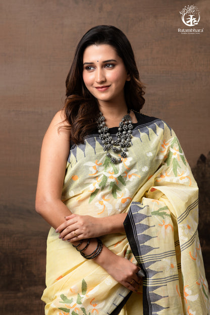 Woman wearing a traditional saree with a floral pattern against a brown background