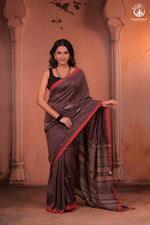 Woman wearing a traditional handwoven kutchhi weave saree with a decorative background in fine cotton yarns with silk threads in extra weft design.