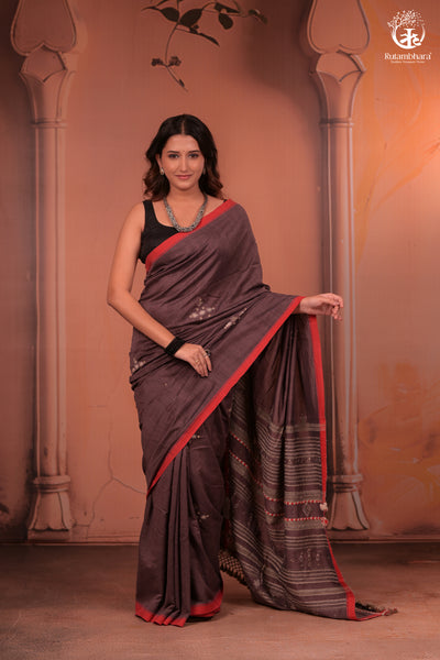 Woman wearing a traditional handwoven kutchhi weave saree with a decorative background in fine cotton yarns with silk threads in extra weft design.