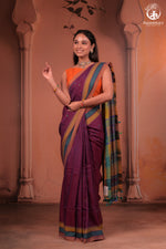 Woman in a traditional Kutchhi weave saree with mirror work embroidery from Bhujodi, kutch  with a decorative background showing the body of the samee , motifs, pallu and borders with brand name Rutambhara in the right top corner.